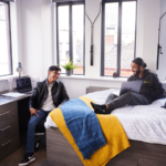 Male Students Relax In Room At Abbey College Manchester